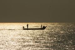 fishermen on boat during sunrise at Marina beach, Chennai