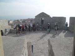 Panoramic view of Dubrovnik's cityscape with orange rooftops and the Adriatic Sea