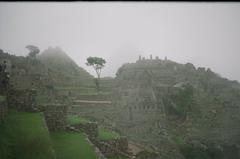 View of Machu Picchu with Huayna Picchu in the background covered in mist