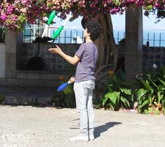 person juggling three balls in a park