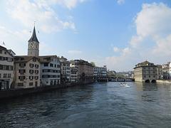 Scenic view of Limmat River with lush greenery and calm waters under a blue sky