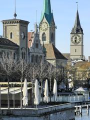 A panoramic view of Fraumünsterpost, Stadthaus Zürich, Fraumünster, Zunfthaus zur Meisen, Münsterbrücke, St. Peter Church, Urania Sternwarte tower, Quaibrücke, Lindenhof hill, Münsterhof, Bauschänzli, and Frauenbadi in Zürich, Switzerland from Quaibrücke.