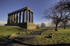 A scenic view of Calton, characterized by rolling hills, lush greenery, and several architectural structures in the landscape.