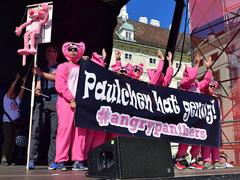 Protestors holding signs at a demonstration against the 12-hour workday in Austria