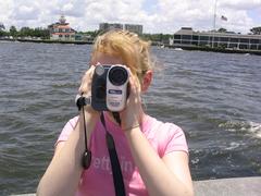 Young woman with Sony 990x video camera on jetty at West End, New Orleans