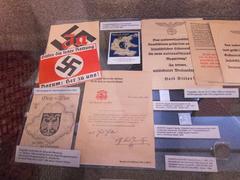 Austrian Nazi propaganda ephemera including postcards, pins, and pamphlets.