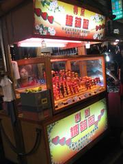 Liouho Night Market in Kaohsiung, Taiwan at night with illuminated storefronts and crowded streets