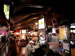 Raohe Street Night Market at night with vibrant lights and crow