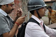 Two bikers using mobile phones in Kolkata