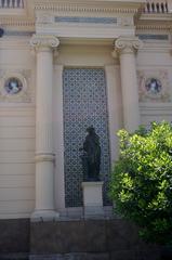 Exterior detail of Palacio Cousiño with sculpture, Italian majolica medallions, and faience panel