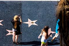 People enjoying a sunny day in Hollywood with street performers and palm trees