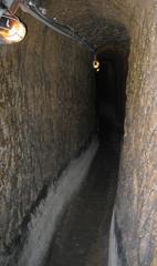 Tuff tunnel beneath Naples with white deposits on lower walls