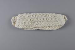 Dambinda, a knitted pad used as a sanitary towel, made of soft cotton yarn and folded into three layers with loops on each end for attaching to a belt.