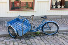 Blue cargo bike parked on a sidewalk