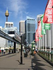 Flags line Pyrmont Bridge with view of Sydney Monorail crossing Darling Harbour