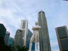 Raffles statue standing by the Singapore River with the financial district in the background