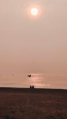 Two friends meditating at sunrise on Vizag beach