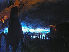 people standing by a lake in a cave