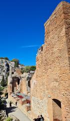 Ancient Greek-Roman theatre in Taormina with mountains in the background