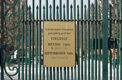 Fence between the palace park and Schönbrunn Zoo with signage to nearby entrances