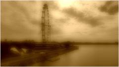 Sepia image of Singapore's well-known Ferris wheel in misty conditions