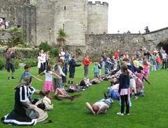 owl flying over people lying on grass at Stirling Castle falconry display