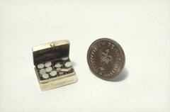 World's smallest medicine chest alongside a half penny