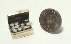 World's smallest medicine chest in Queen Mary's doll house with a half penny for size comparison