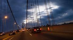 Bay Bridge at night with a traffic cone and San Francisco skyline