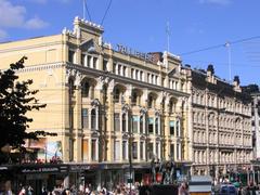 Aleksanterinkatu street buildings 19 and 21 in Helsinki with The Three Smiths statue in the foreground