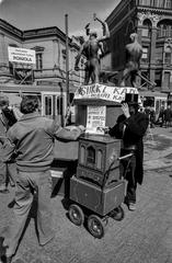 Man placing money in a street musician's collection cup during a street music event at Kolmen sepän aukio