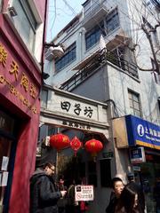 Tianzifang in Shanghai, featuring a narrow alley with shops and people.