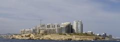 Bird's eye view of Malta's coastline featuring architectural landscapes and harbor