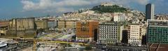 Scenic view of Naples from a cruise ship in the harbor, featuring Castel Nuovo on the left and Castel Sant'Elmo at the top center.