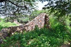 Tomb of Balban Khan in ruins surrounded by grassy area