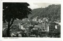 Old postcard of Hirschensprungzeile in Karlsbad with vintage cars and buildings from 1930