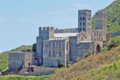 Distant view of the Benedictine abbey of Sant Pere de Rodes on the heights of Cap Creus, Spain, featuring a Romanesque Lombard-style bell tower and a defense tower