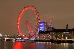 Cityscape view of London with illuminated London Eye Ferris wheel at dusk