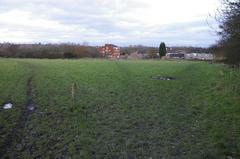 Field on edge of Woodgate Valley Country Park with council estate in the background