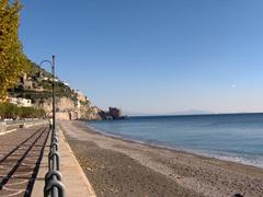 Maiori beach in Italy with clear blue waters and rocky hills in the background