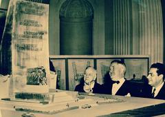 Three men viewing the model of the Good Neighbor Policy monument