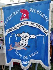 Confrérie Rochelaise banner depicting a calf's head eating a fish