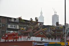 View of Taipei 101, a skyscraper under construction, apartment buildings, and a temple at Wufenpu