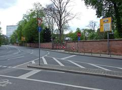 Entrance gate to Bethmannpark in Frankfurt with White Wall of the Water Pavilion of the Refined Heart in the background