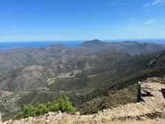 Castell de Verdera ruins against a backdrop of mountains and clear sky