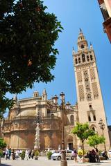 Aerial view of the Plaza de España in Seville, Spain, showcasing the semi-circular building and central fountain with people walking around