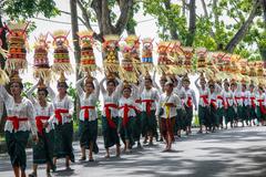 Balinese women participating in the Mapeed tradition, carrying fruit and traditional snacks on their heads