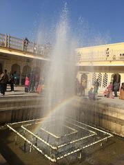 sun rays creating a rainbow over a fountain in Hawa Mahal courtyard