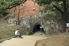 Drachenhöhle exit with person sitting on a chair ensuring proper direction at the Vistula River bank