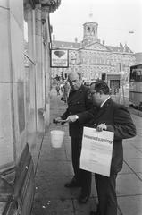 Officials pasting warning posters against heroin trade on the Dam